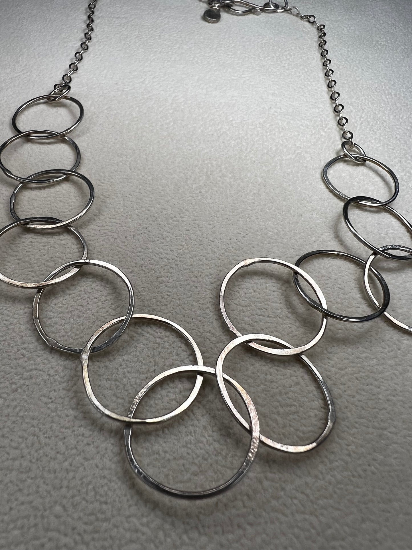This 20" sterling silver ring and link necklace is thoughtfully crafted to add a touch of elegance and confidence to your favorite outfits. Let this necklace be the special piece that completes your wardrobe with grace and charm.