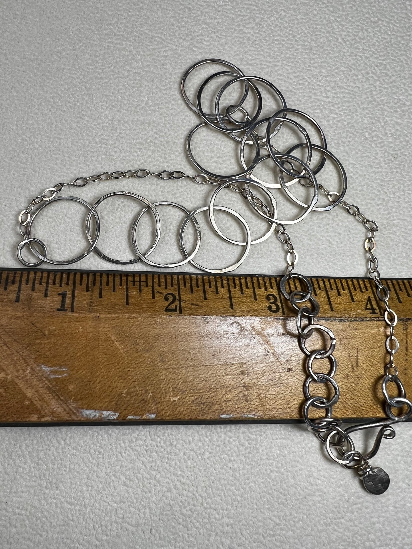 This 20" sterling silver ring and link necklace is thoughtfully crafted to add a touch of elegance and confidence to your favorite outfits. Let this necklace be the special piece that completes your wardrobe with grace and charm.