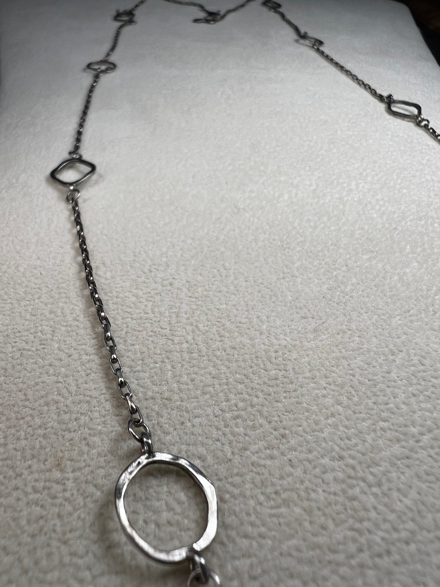 This retired Silpada necklace, measuring 34" in length, is crafted from sterling silver and accented with a few sparkling cubic zirconia stones. This "Ring Around the Rosy" necklace offers a subtle flash of light, making it a charming and elegant addition to any jewelry collection.