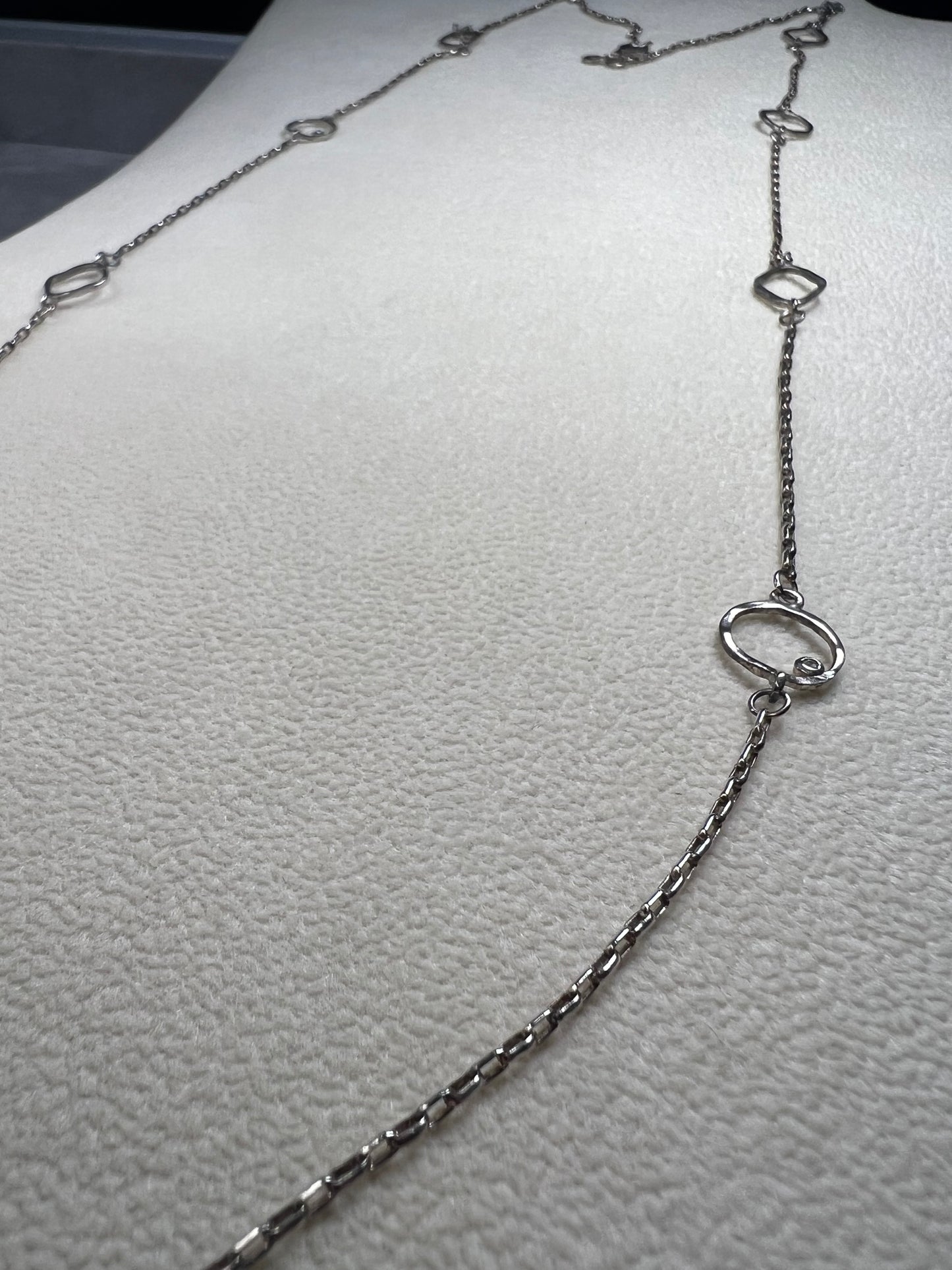 This retired Silpada necklace, measuring 34" in length, is crafted from sterling silver and accented with a few sparkling cubic zirconia stones. This "Ring Around the Rosy" necklace offers a subtle flash of light, making it a charming and elegant addition to any jewelry collection.