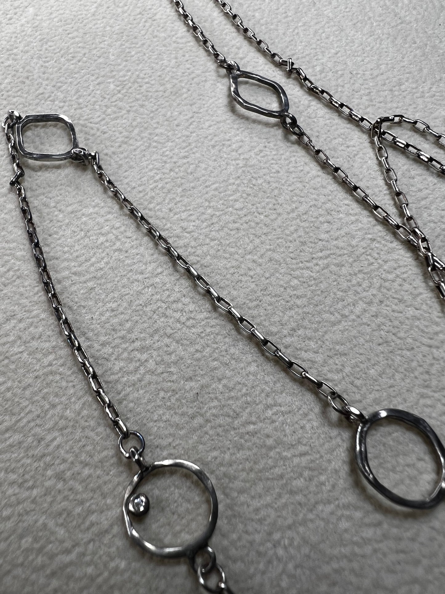 This retired Silpada necklace, measuring 34" in length, is crafted from sterling silver and accented with a few sparkling cubic zirconia stones. This "Ring Around the Rosy" necklace offers a subtle flash of light, making it a charming and elegant addition to any jewelry collection.