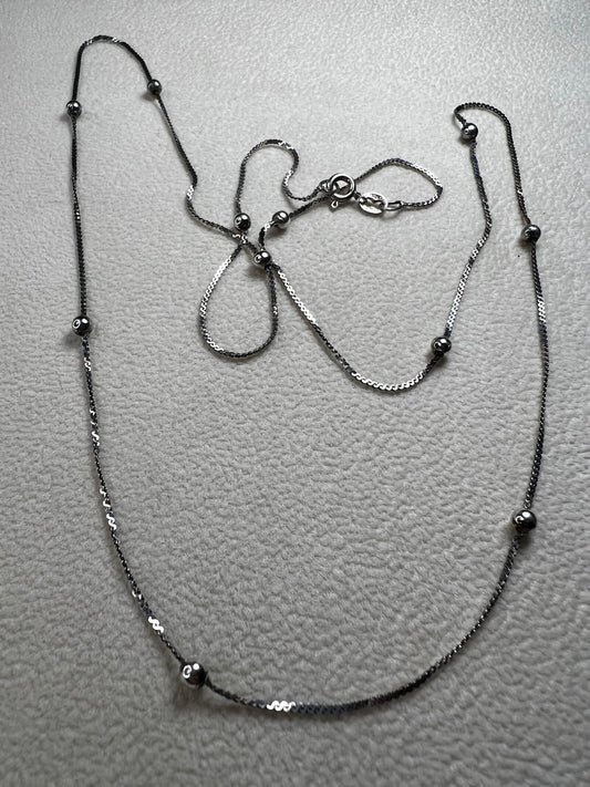 This vintage Italian sterling silver necklace features 11 small sterling silver balls spaced apart, creating an elegant and distinctive design. Its timeless style makes it a versatile accessory that enhances any outfit with subtle sophistication.