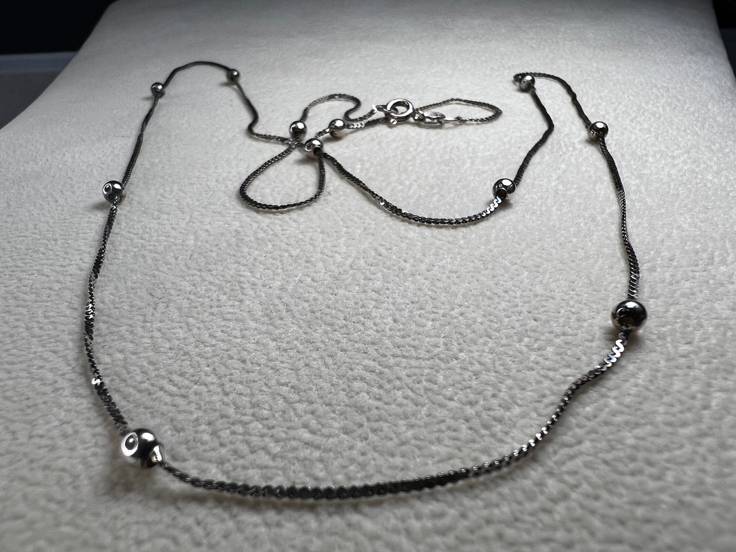 This vintage Italian sterling silver necklace features 11 small sterling silver balls spaced apart, creating an elegant and distinctive design. Its timeless style makes it a versatile accessory that enhances any outfit with subtle sophistication.