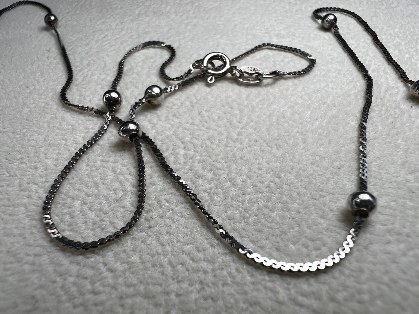 This vintage Italian sterling silver necklace features 11 small sterling silver balls spaced apart, creating an elegant and distinctive design. Its timeless style makes it a versatile accessory that enhances any outfit with subtle sophistication.