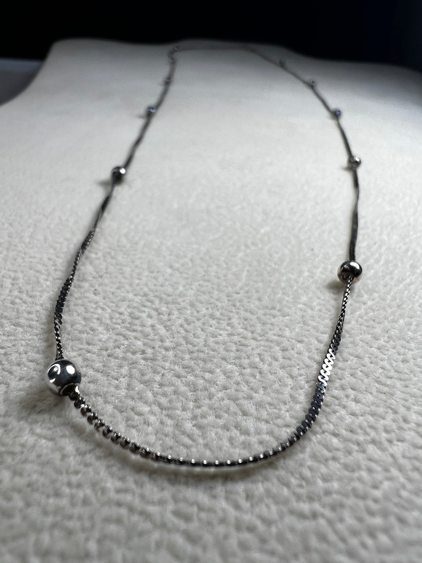 This vintage Italian sterling silver necklace features 11 small sterling silver balls spaced apart, creating an elegant and distinctive design. Its timeless style makes it a versatile accessory that enhances any outfit with subtle sophistication.