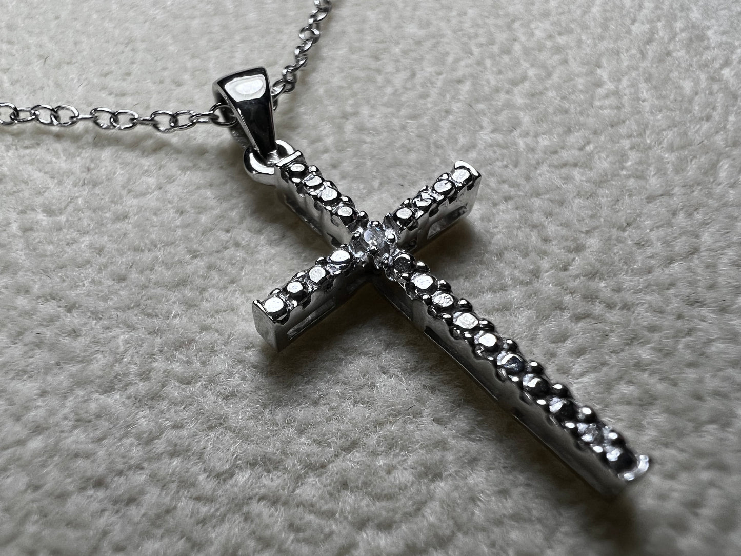 This sterling silver cross pendant necklace from V3 Jewelers features a single center diamond, combining classic design with subtle sparkle. This is a meaningful accessory that adds a graceful touch to any outfit while symbolizing faith and style.