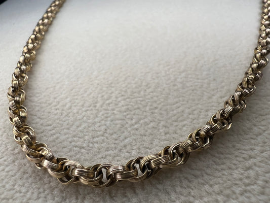This vintage 26" gold-filled chain features a sturdy double spiral weave, measuring 3.5mm thick for lasting strength. Its elegant gold finish shines on its own while providing a reliable base for any pendant.