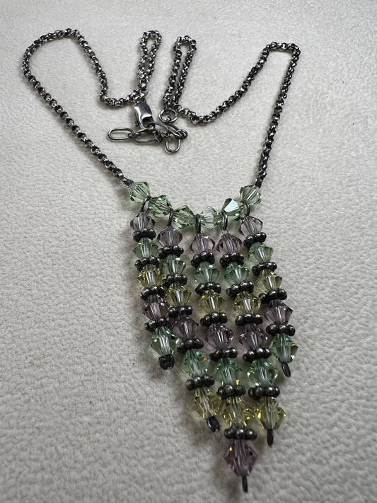 This vintage necklace features a sterling silver chain beautifully complemented by five crystal beaded strands that hang elegantly, creating a distinctive and timeless look.