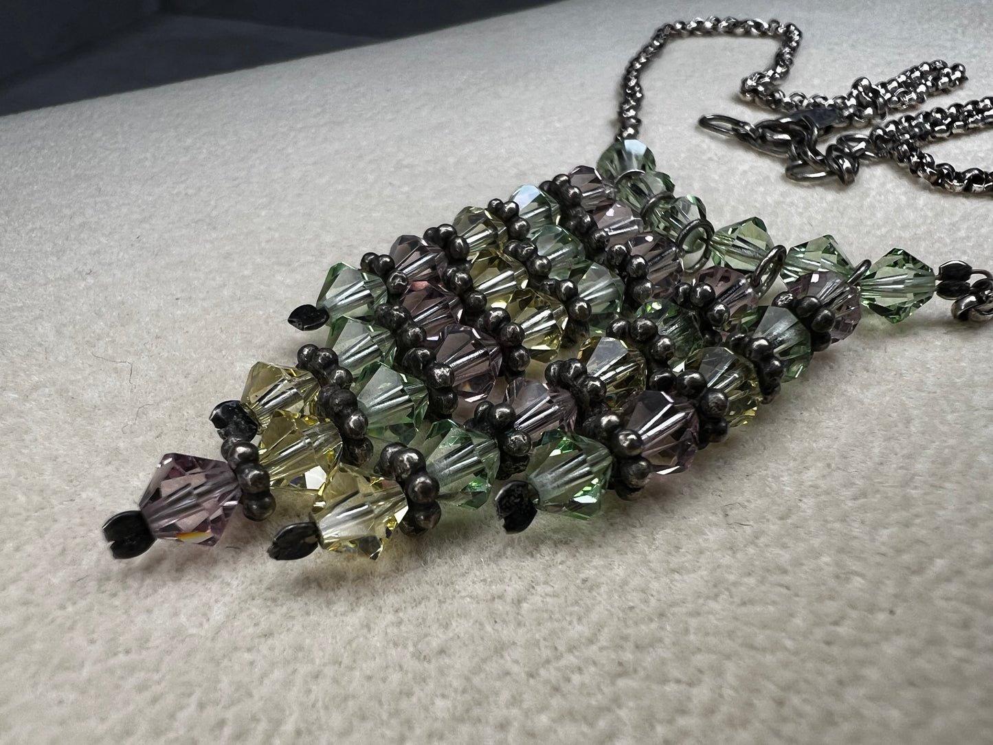 This vintage necklace features a sterling silver chain beautifully complemented by five crystal beaded strands that hang elegantly, creating a distinctive and timeless look.