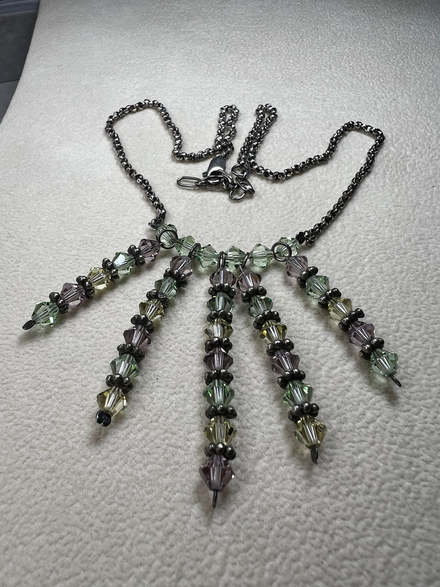 This vintage necklace features a sterling silver chain beautifully complemented by five crystal beaded strands that hang elegantly, creating a distinctive and timeless look.