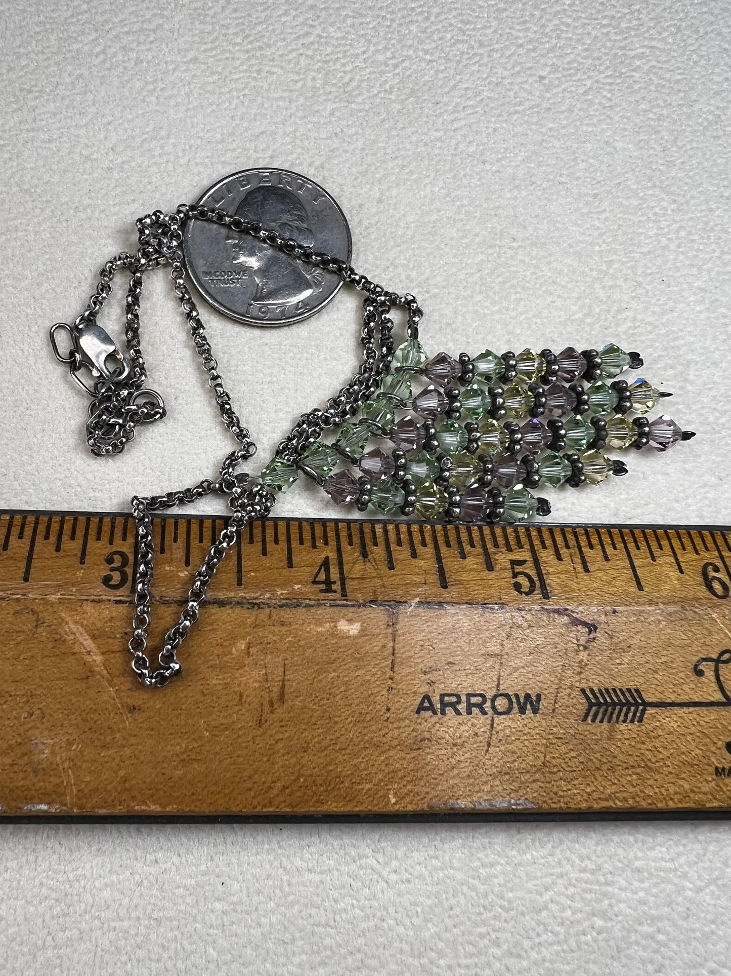 This vintage necklace features a sterling silver chain beautifully complemented by five crystal beaded strands that hang elegantly, creating a distinctive and timeless look.