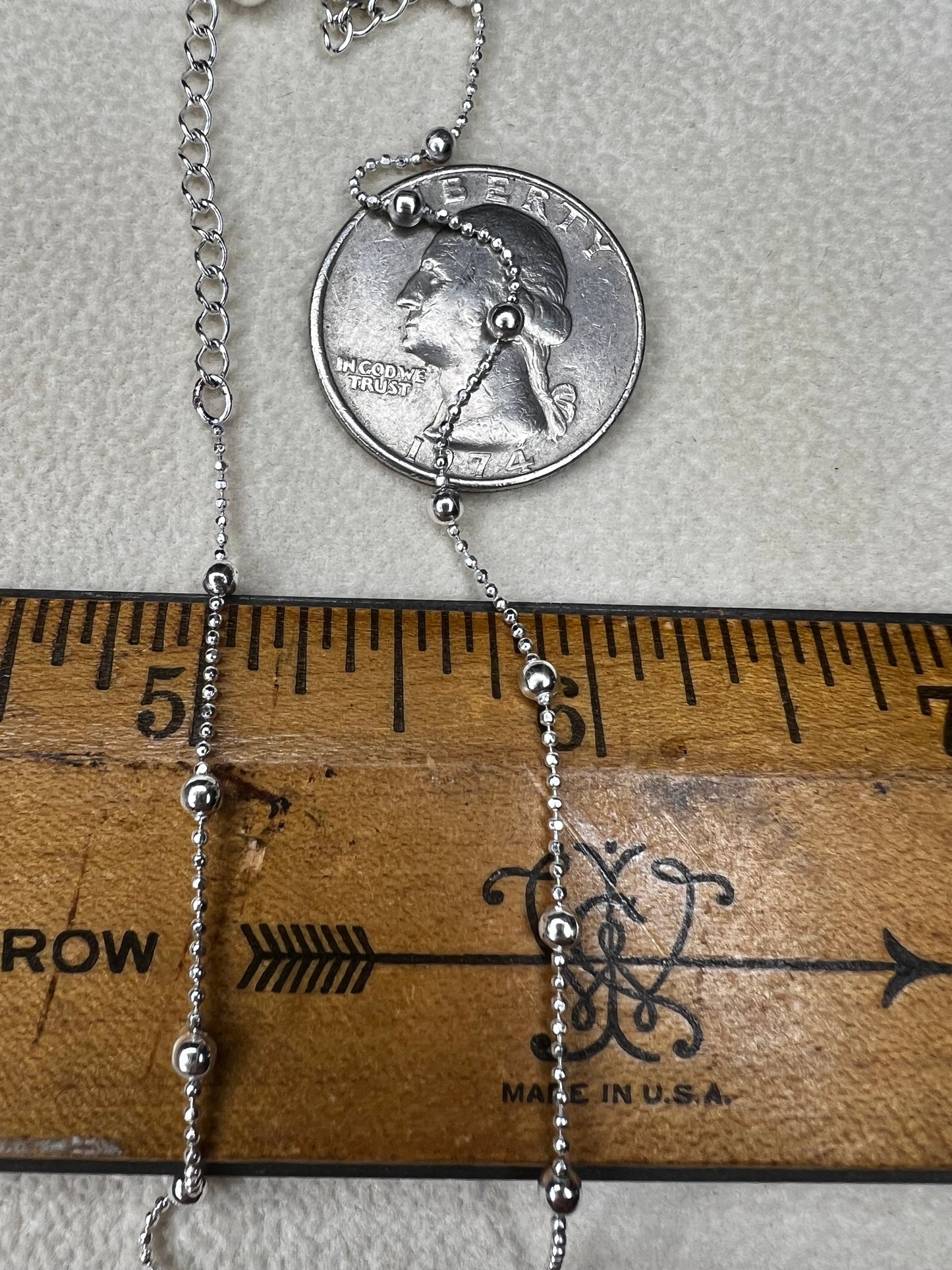 This 15" Italian sterling silver necklace features a bright finish that catches the light beautifully. Its delicate design combines tiny beads with slightly larger spaced beads, creating a simple yet striking accessory that adds subtle elegance to any outfit.