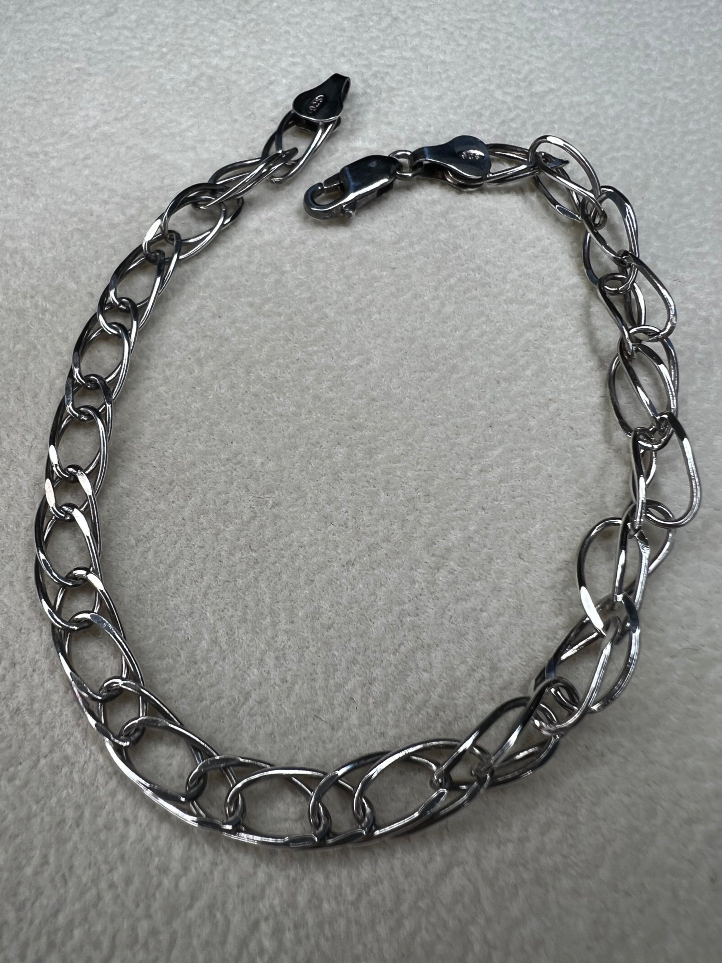 This sterling silver bracelet showcases a timeless design that stands out on its own or can be personalized as a charm bracelet.