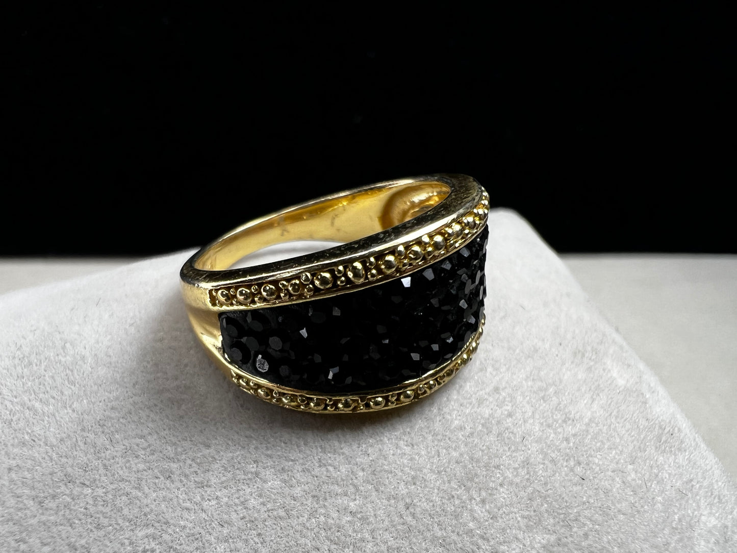 Crafted from sterling silver with a luxurious gold overlay, this ring features a cluster of black crystals nestled within a detailed frame. This piece offers both refined style and enduring sophistication.