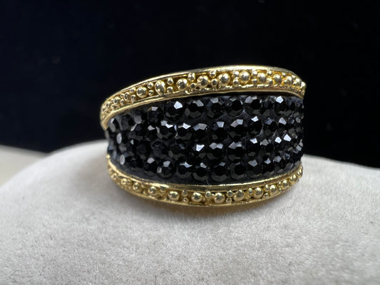 Crafted from sterling silver with a luxurious gold overlay, this ring features a cluster of black crystals nestled within a detailed frame. This piece offers both refined style and enduring sophistication.