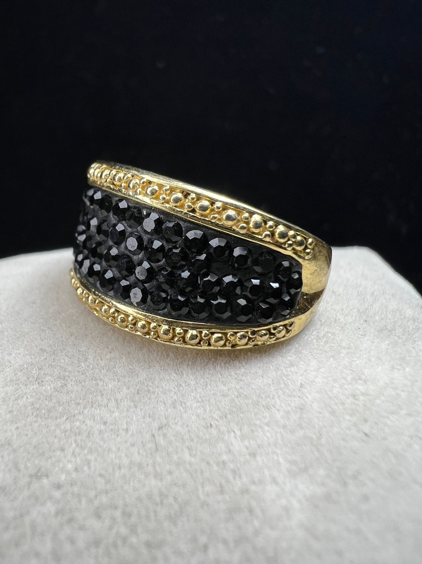 Crafted from sterling silver with a luxurious gold overlay, this ring features a cluster of black crystals nestled within a detailed frame. This piece offers both refined style and enduring sophistication.