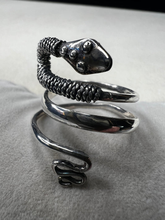 This sterling silver snake wrap ring gently coils around your finger with an open design, allowing for easy size adjustment. Its flexible fit ensures comfortable wear while adding a sleek, stylish touch to your collection.