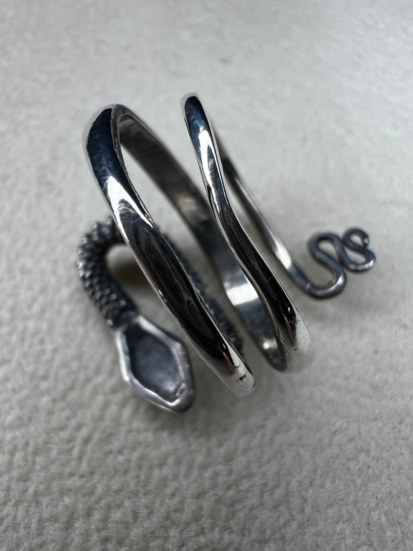 This sterling silver snake wrap ring gently coils around your finger with an open design, allowing for easy size adjustment. Its flexible fit ensures comfortable wear while adding a sleek, stylish touch to your collection.