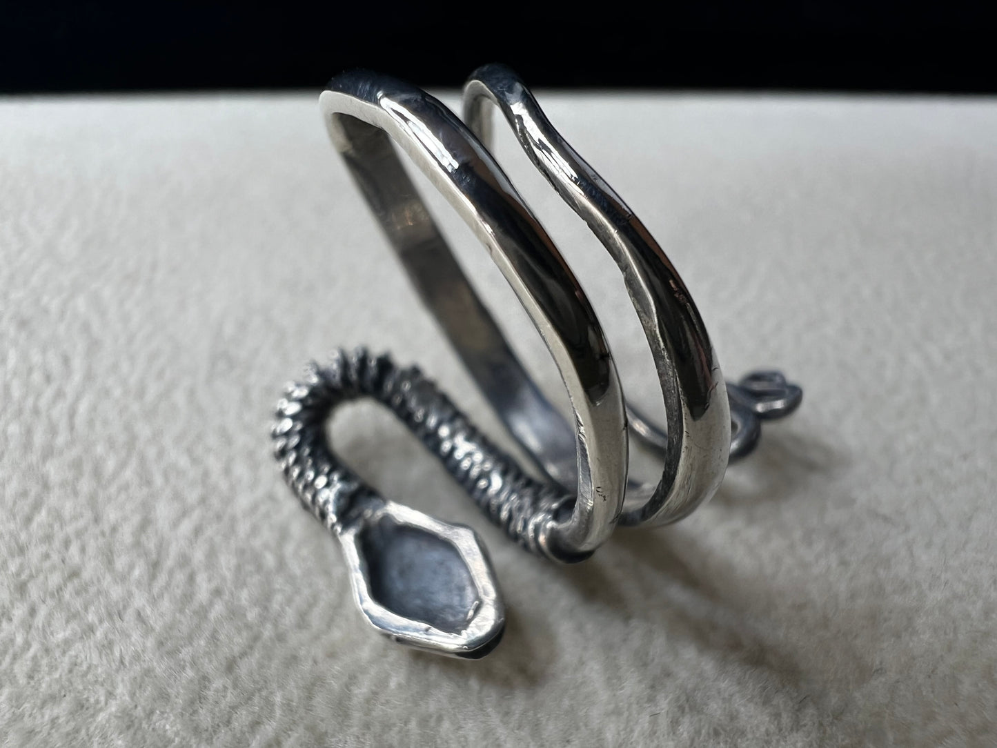 This sterling silver snake wrap ring gently coils around your finger with an open design, allowing for easy size adjustment. Its flexible fit ensures comfortable wear while adding a sleek, stylish touch to your collection.
