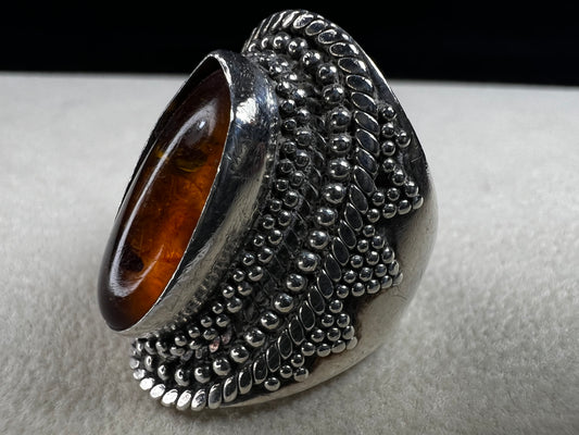 This vintage sterling silver ring features Balinese craftsmanship and a glowing amber cabochon. Made in Indonesia, it blends natural beauty with artisan elegance.