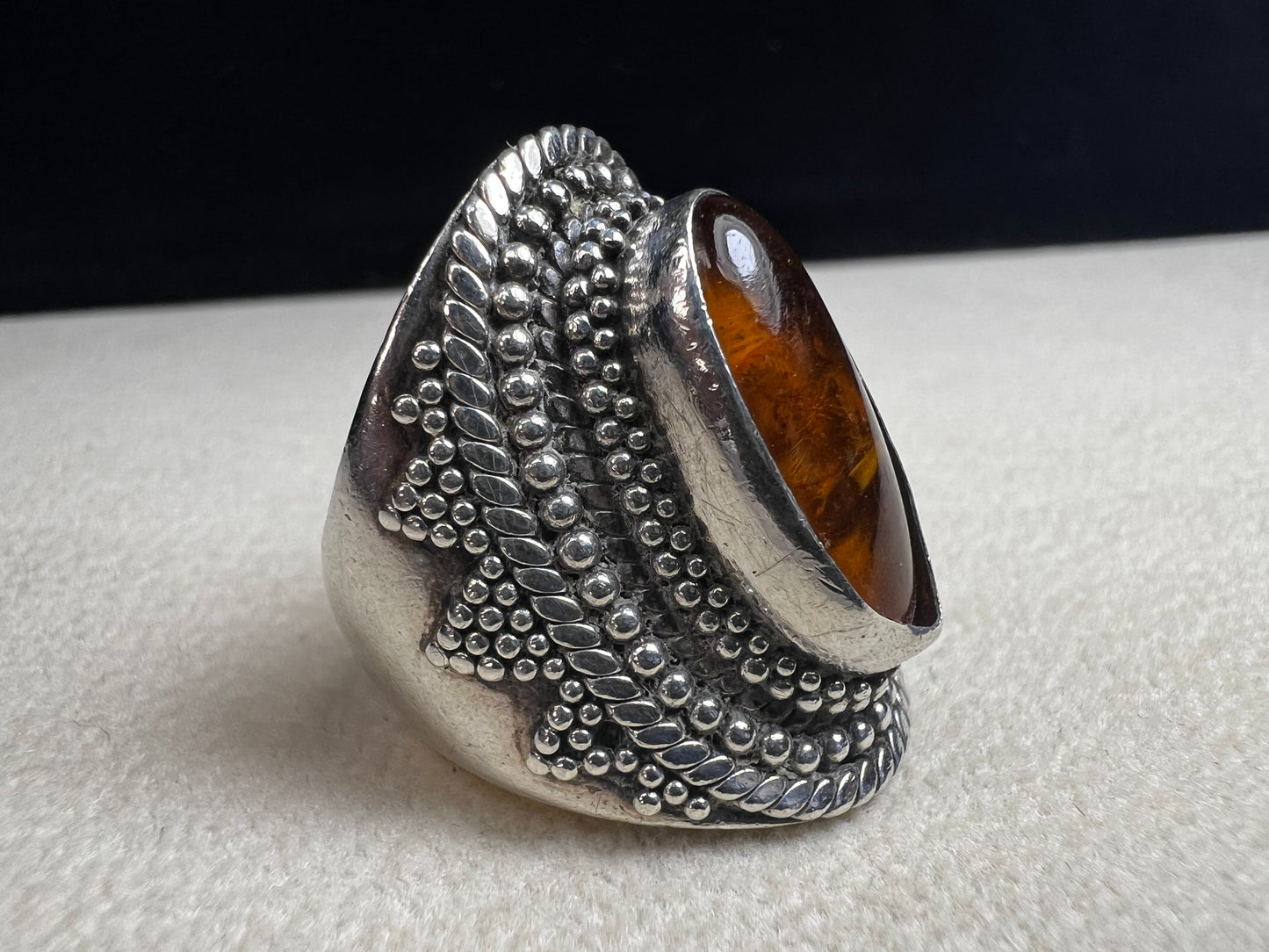 This vintage sterling silver ring features Balinese craftsmanship and a glowing amber cabochon. Made in Indonesia, it blends natural beauty with artisan elegance.