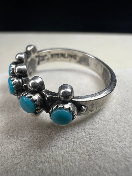 This striking vintage ring features vibrant sky-blue turquoise cabochons set in serrated bezels, accented with bold silver beadwork. Crafted in solid sterling silver, the piece carries the hallmark of Bell Trading Post, a well-known Southwestern jewelry company active from the 1930s through the 1970s.