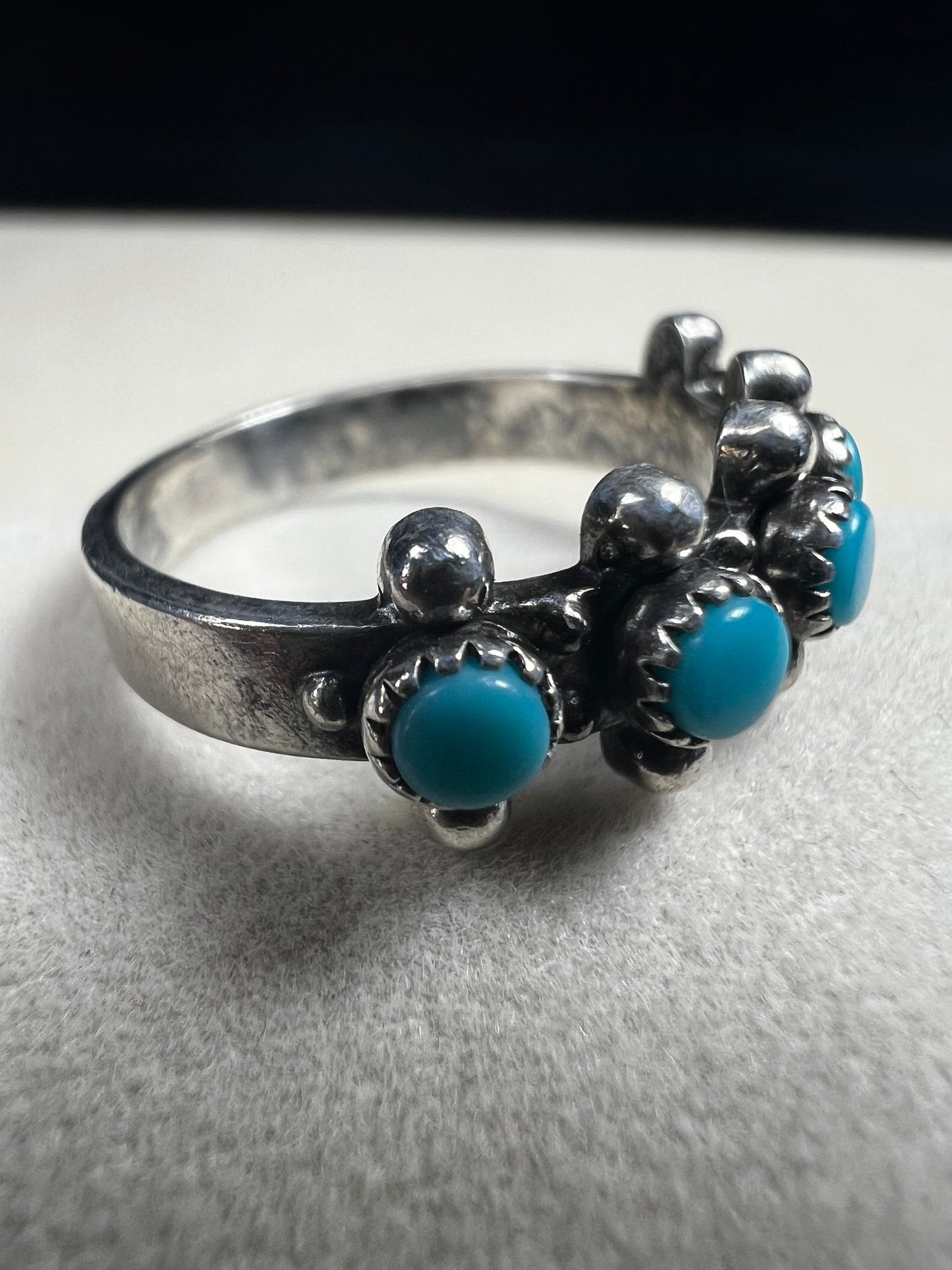 This striking vintage ring features vibrant sky-blue turquoise cabochons set in serrated bezels, accented with bold silver beadwork. Crafted in solid sterling silver, the piece carries the hallmark of Bell Trading Post, a well-known Southwestern jewelry company active from the 1930s through the 1970s.