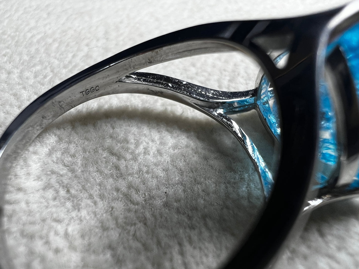 This sterling silver ring showcases a large, blue trilliant cut crackled quartz, creating a captivating centerpiece. Perfect for adding a touch of elegance and distinctiveness to any outfit.