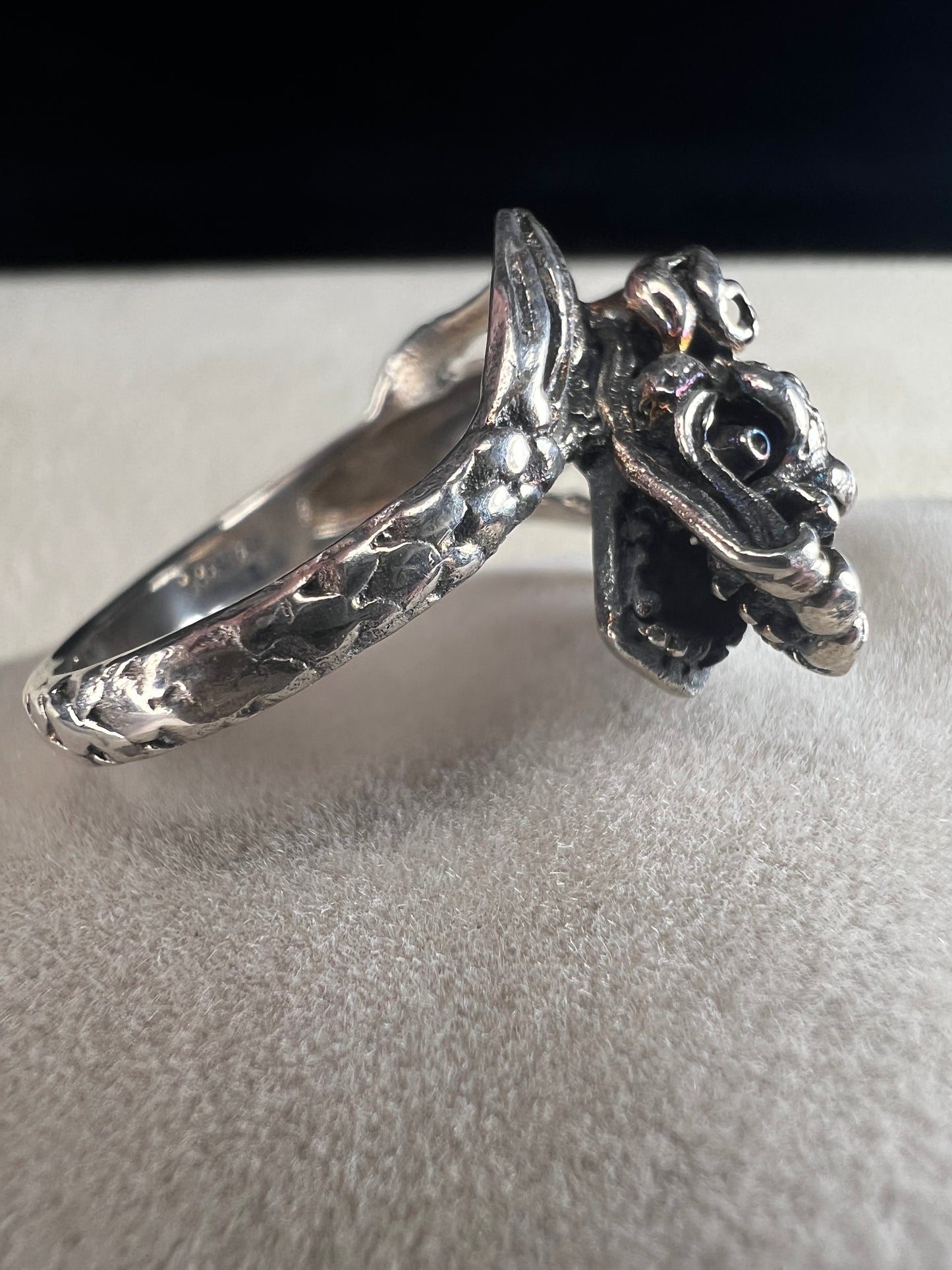 Add a touch of fierce charm to your style with this sterling silver dragon ring. Its detailed design wraps around your finger like a mythical guardian, making it the perfect statement piece.