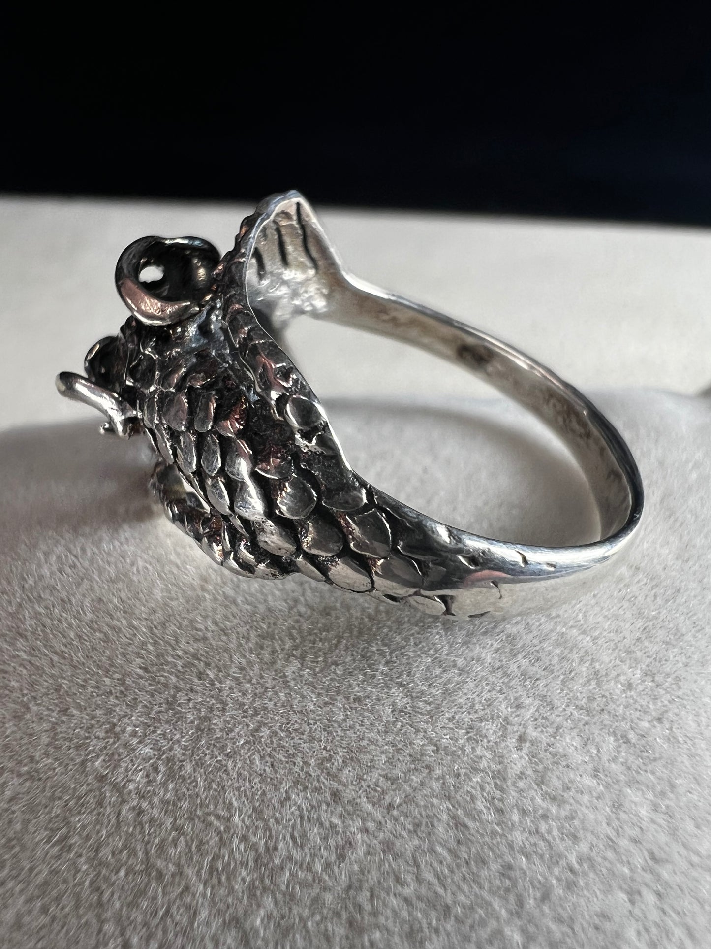Add a touch of fierce charm to your style with this sterling silver dragon ring. Its detailed design wraps around your finger like a mythical guardian, making it the perfect statement piece.