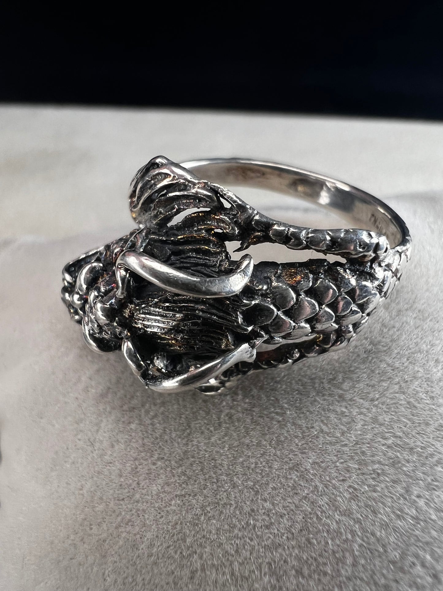 Add a touch of fierce charm to your style with this sterling silver dragon ring. Its detailed design wraps around your finger like a mythical guardian, making it the perfect statement piece.