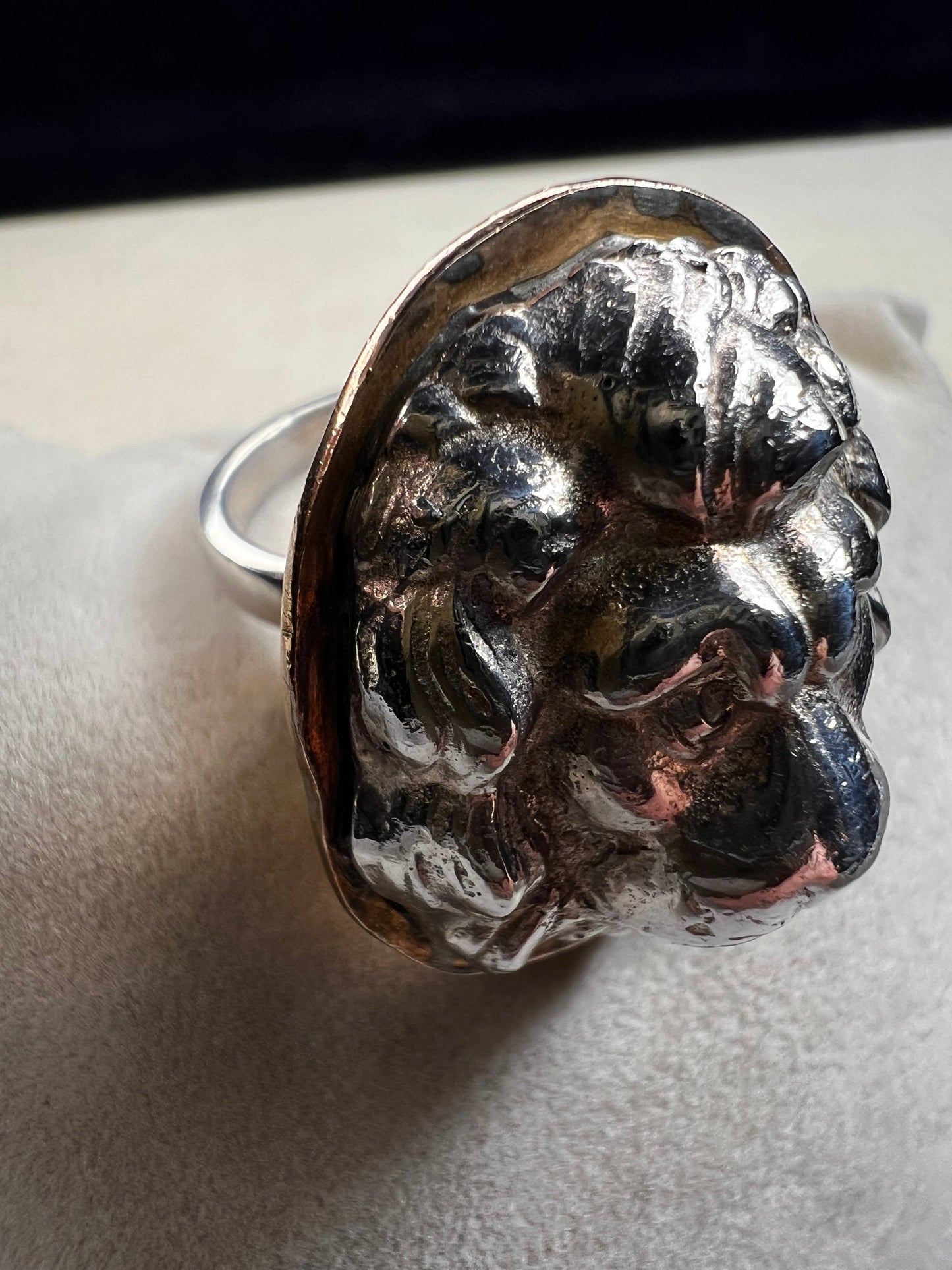 This sterling silver ring by Loving Anvil features a striking lion's head design, expertly crafted for a bold and unique statement. The backing plate is finished in fine gold, adding a stylish two-tone effect.