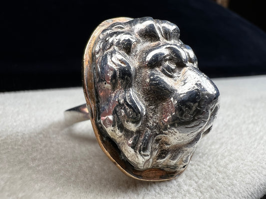 This sterling silver ring by Loving Anvil features a striking lion's head design, expertly crafted for a bold and unique statement. The backing plate is finished in fine gold, adding a stylish two-tone effect.