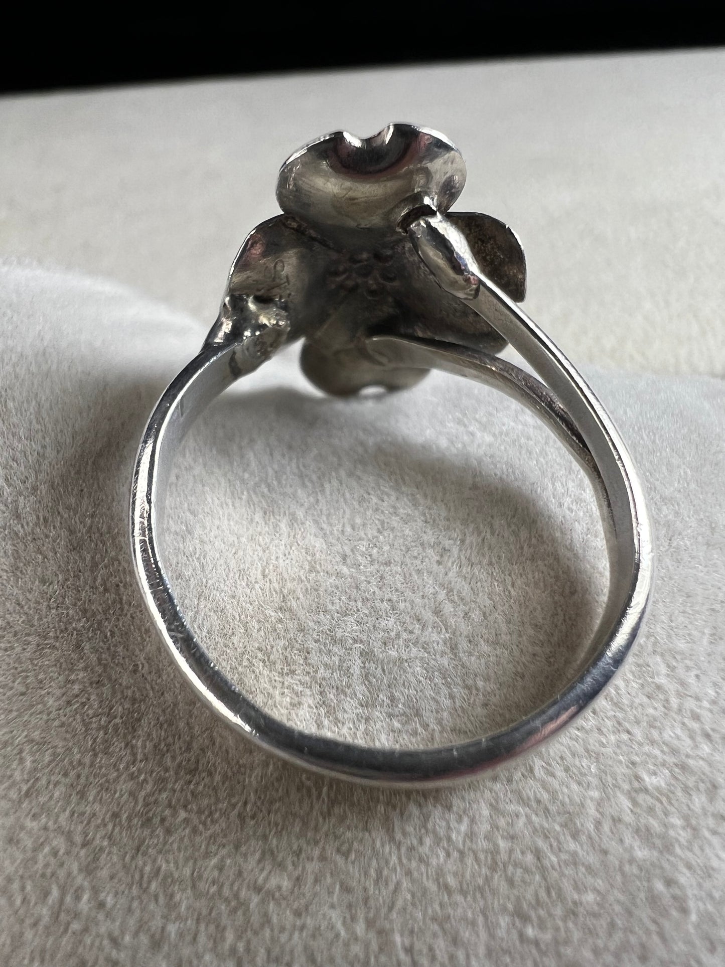 This sterling silver ring by Stuart Nye showcases a delicate dogwood flower design, combining artistry with elegant craftsmanship. Its refined detail makes it a meaningful accessory that adds a touch of nature-inspired beauty to any outfit.