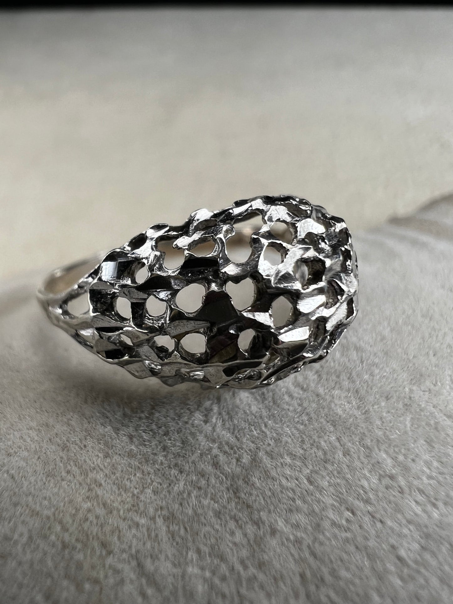 This sterling silver ring features a modern design with diamond-cut detailing that creates the timeless look of a classic nugget ring. Its open work adds elegance and depth, offering a unique style that blends contemporary flair with vintage charm for everyday wear.