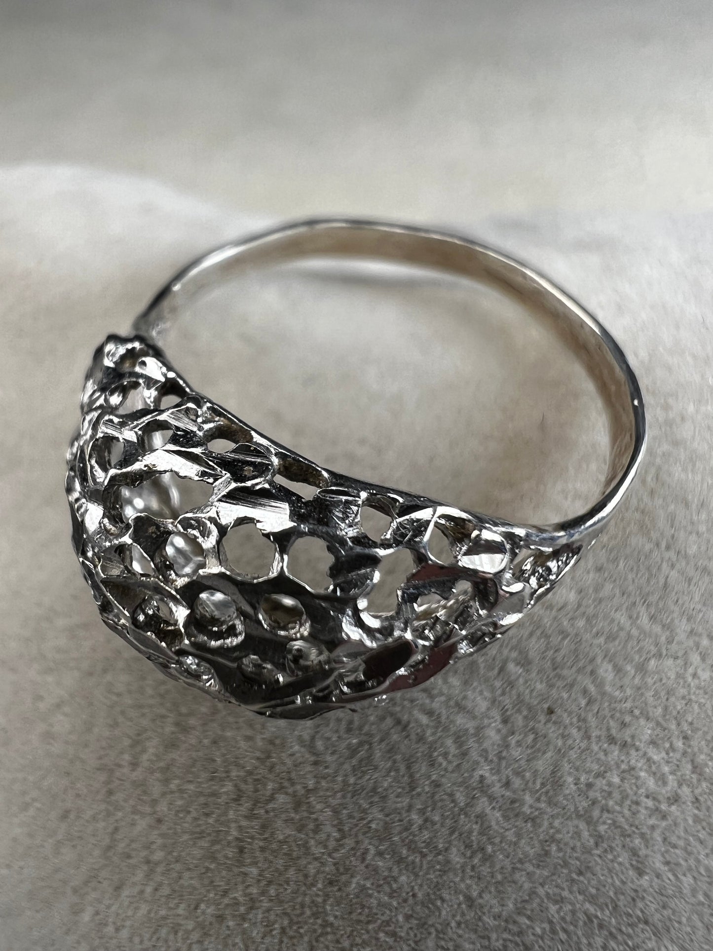 This sterling silver ring features a modern design with diamond-cut detailing that creates the timeless look of a classic nugget ring. Its open work adds elegance and depth, offering a unique style that blends contemporary flair with vintage charm for everyday wear.