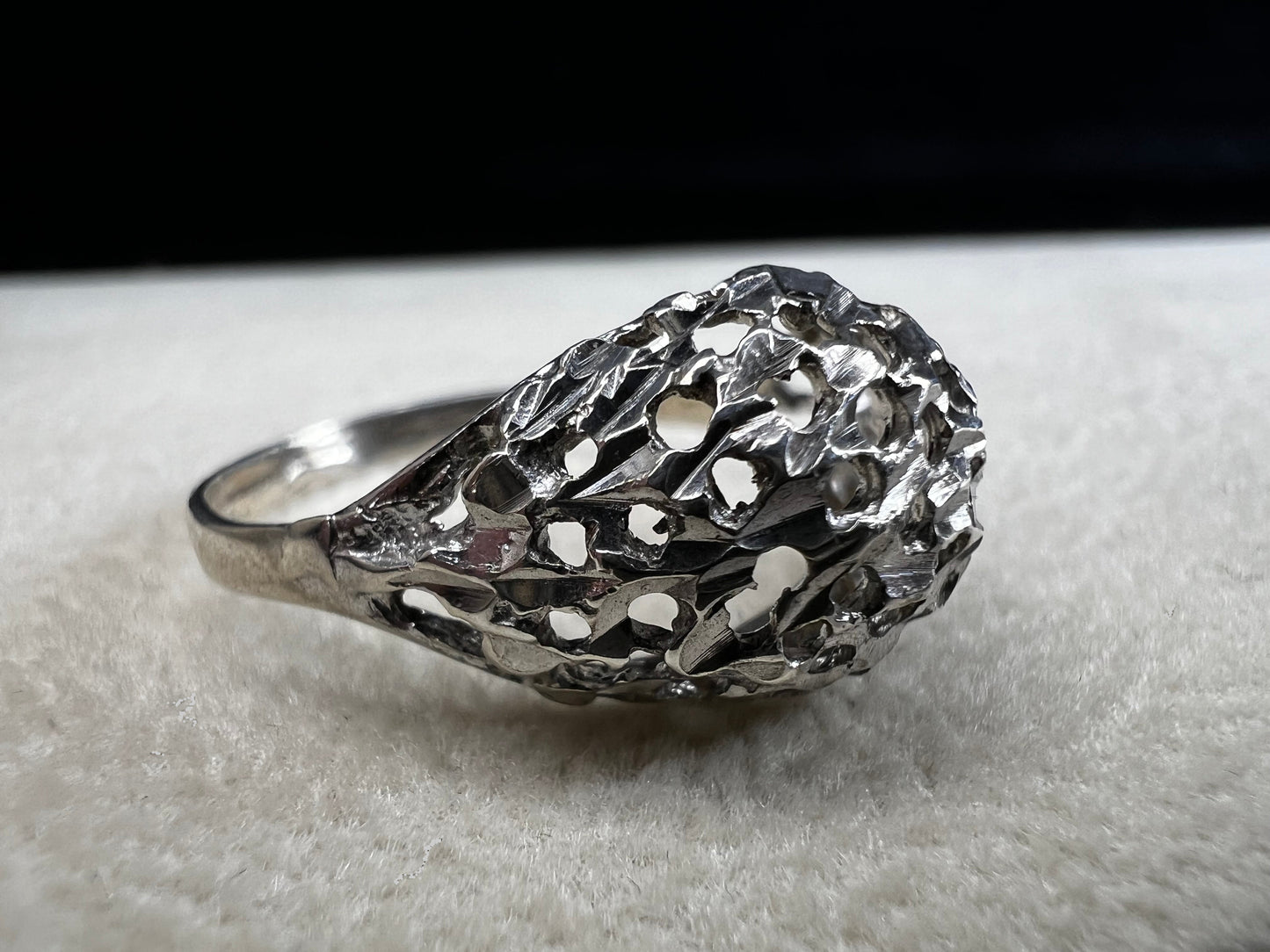 This sterling silver ring features a modern design with diamond-cut detailing that creates the timeless look of a classic nugget ring. Its open work adds elegance and depth, offering a unique style that blends contemporary flair with vintage charm for everyday wear.