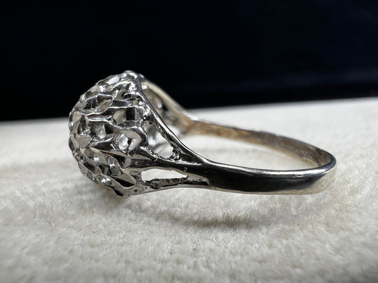 This sterling silver ring features a modern design with diamond-cut detailing that creates the timeless look of a classic nugget ring. Its open work adds elegance and depth, offering a unique style that blends contemporary flair with vintage charm for everyday wear.