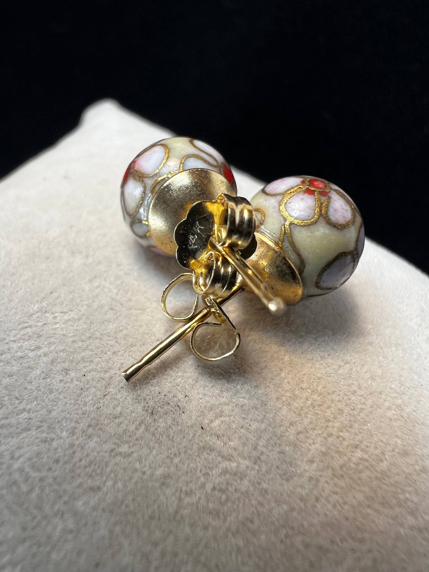 This pair of earrings features an 8 mm cloisonné ball with 14k gold posts and backs. Cloisonné is the art of creating a design on an object by attaching small pieces of wire to a base and filling the compartments with enamel.