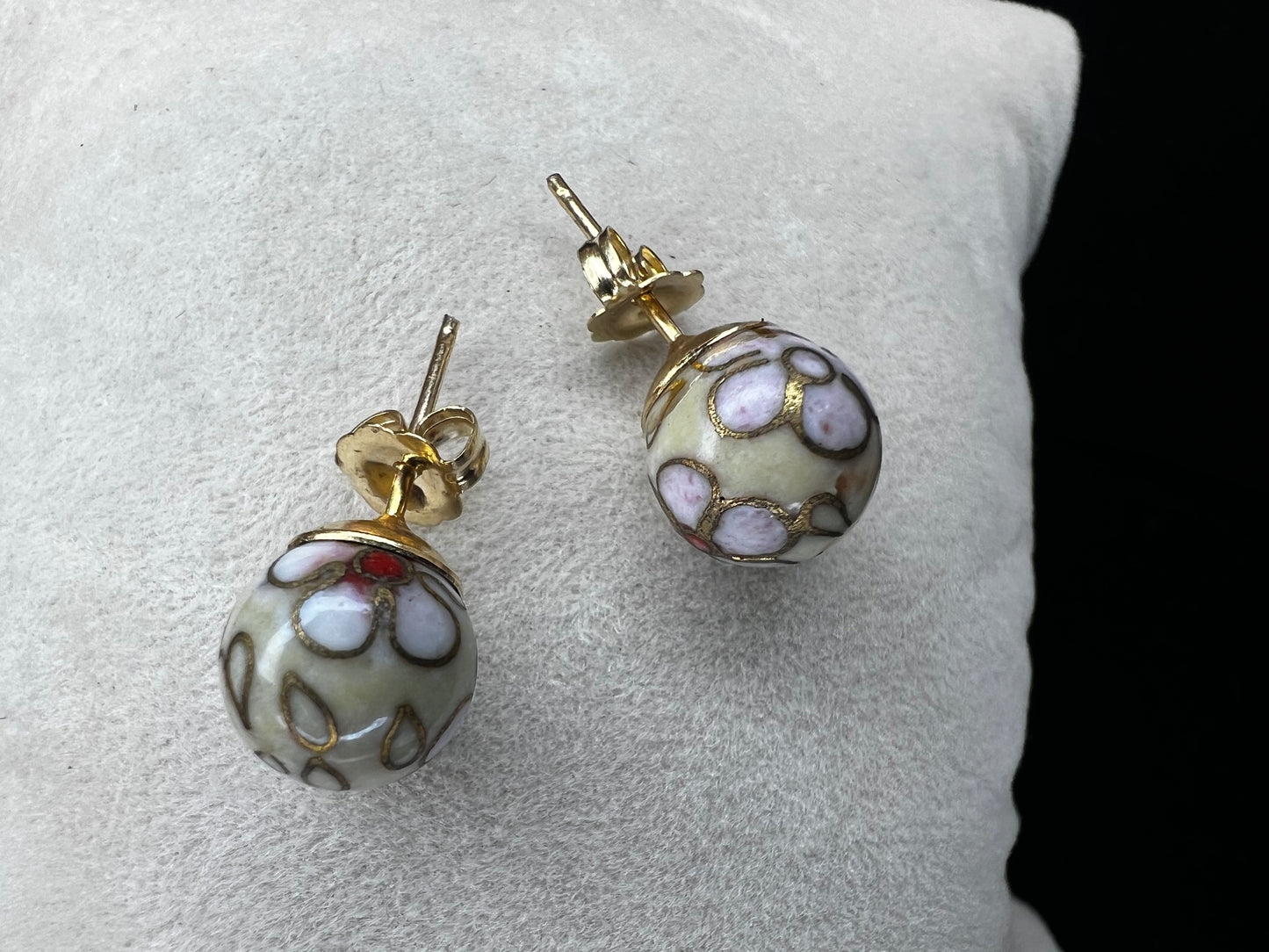 This pair of earrings features an 8 mm cloisonné ball with 14k gold posts and backs. Cloisonné is the art of creating a design on an object by attaching small pieces of wire to a base and filling the compartments with enamel.