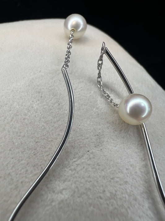 The unique design of these earrings will ensure they will never fall out. Made from 14k white gold, the curved end goes in from the front, leaving a small chain and pearl to drop in front and the curved design to drop in the back.