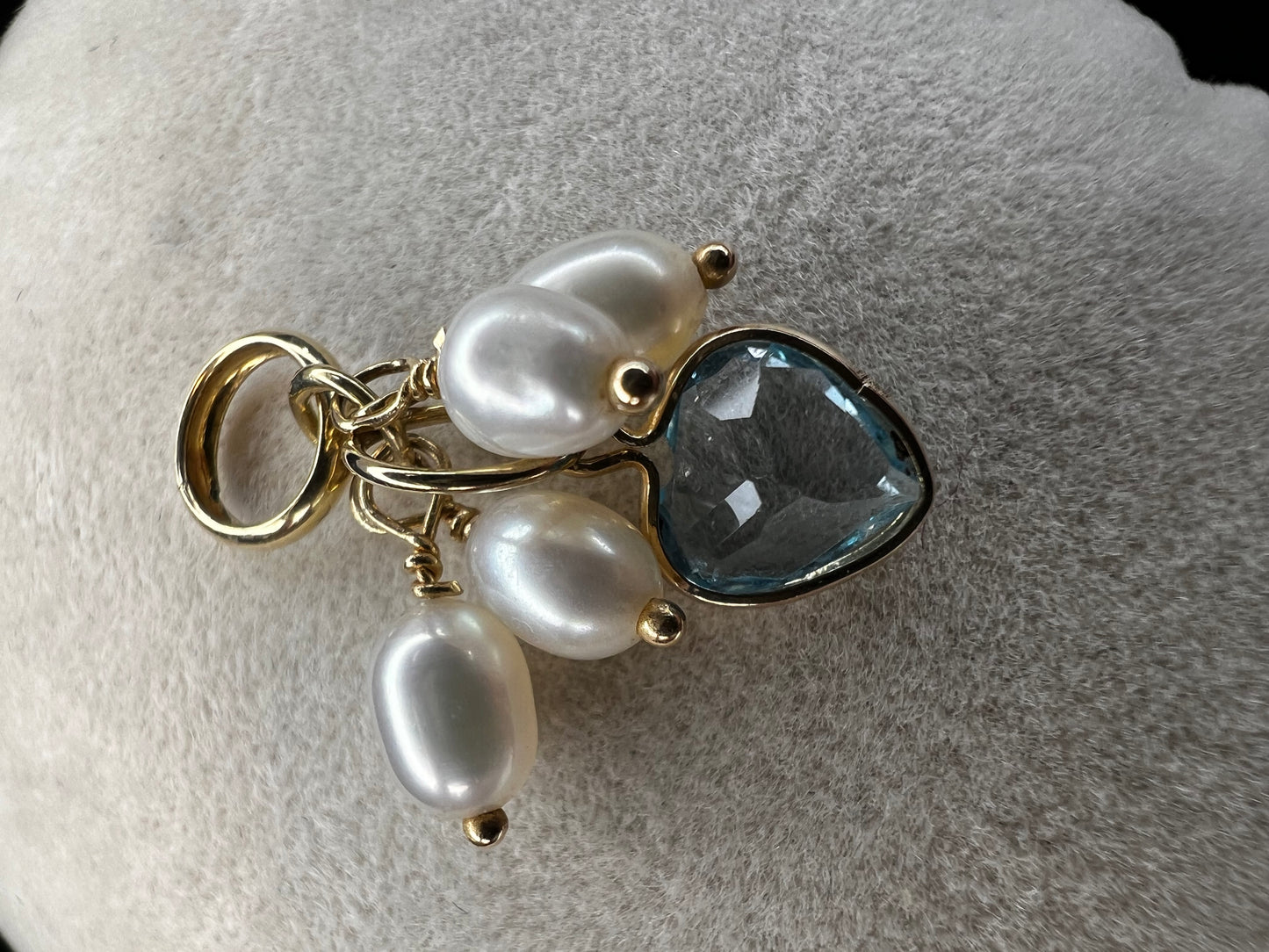 Crafted form 14k gold, this piece features four pearls and a heart shaped topaz. It can be worn as a pendant or a charm.