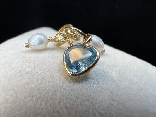 Crafted form 14k gold, this piece features four pearls and a heart shaped topaz. It can be worn as a pendant or a charm.
