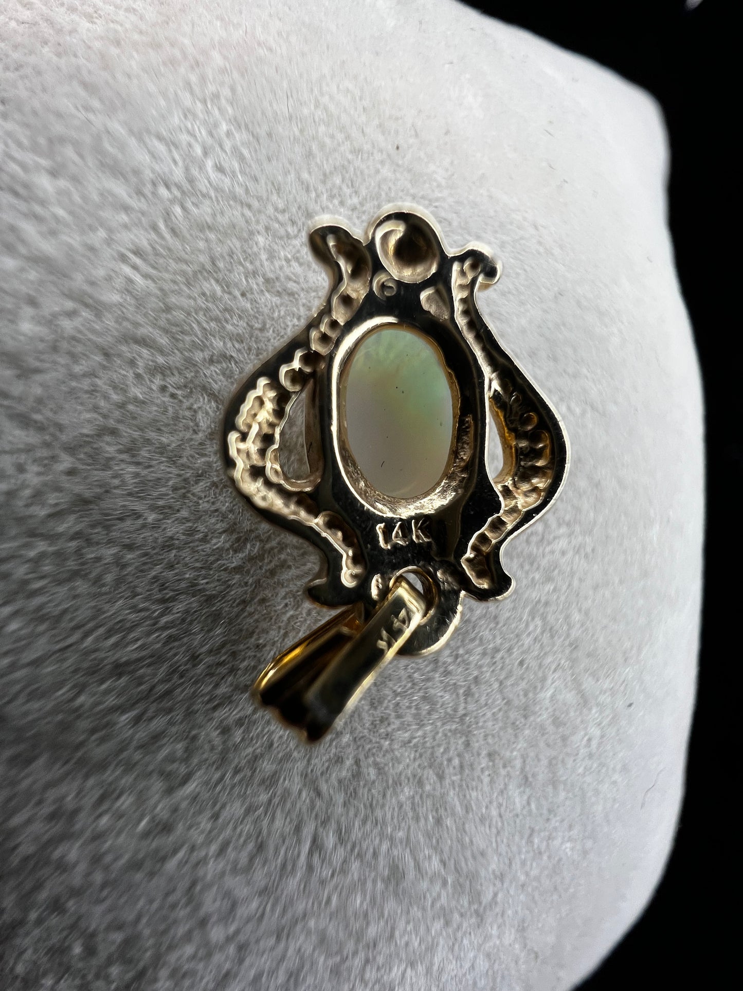 Set amid 14 karat gold, this beautiful opal pendant flashes hues of red, green, blue and yellow. Pair it with one of our gold chains.