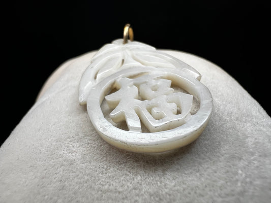 This beautiful pendant is hand-carved from mother of pearl. It is fitted with a 14 karat gold jump ring/bail.