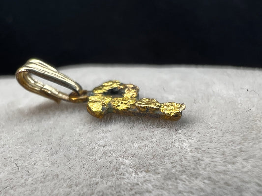 This small vintage pendant screams individuality. The "P" is crafted from brass with solid 24 karat gold nuggets attached to the front of it.