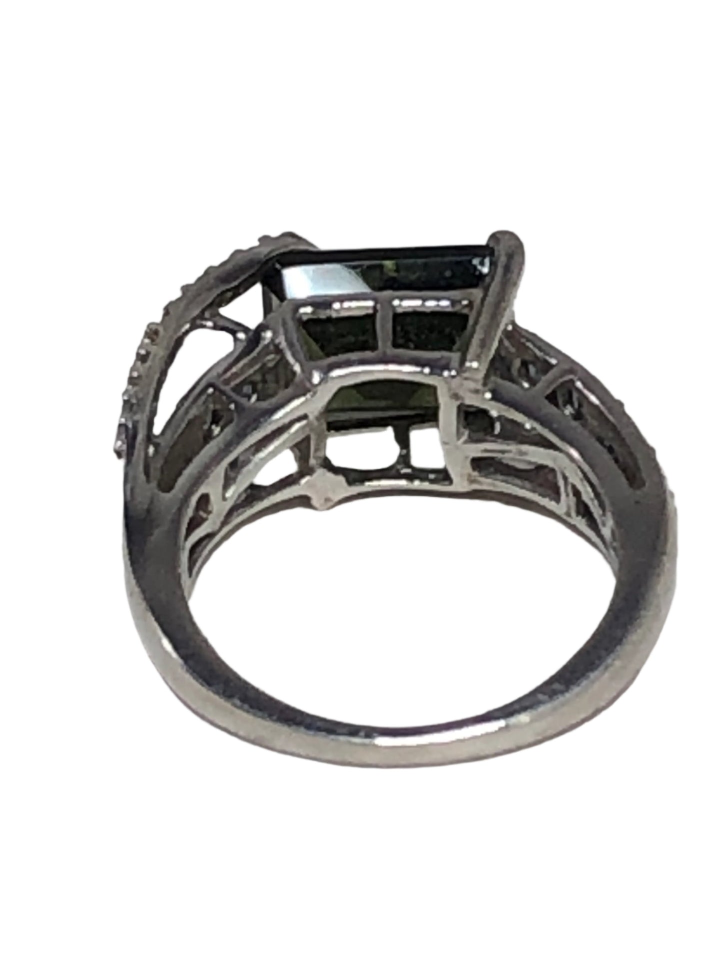 This ring oozes elegance and individuality. Crafted with fine sterling silver, it features a faceted glass stone with a green hue. The stones on each side of the centerpiece add subtle flashes of blue.