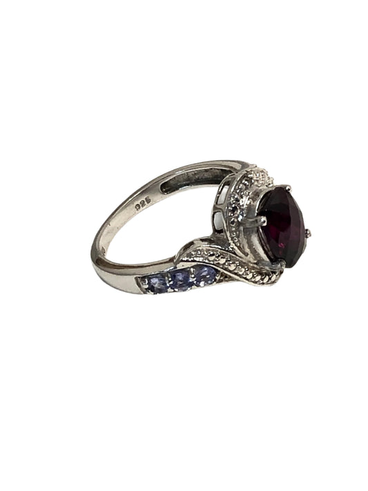 This sterling silver ring boasts a purple tourmaline centerpiece with a stylishly faceted cut. Each side of the band features smaller pale purple tourmalines.