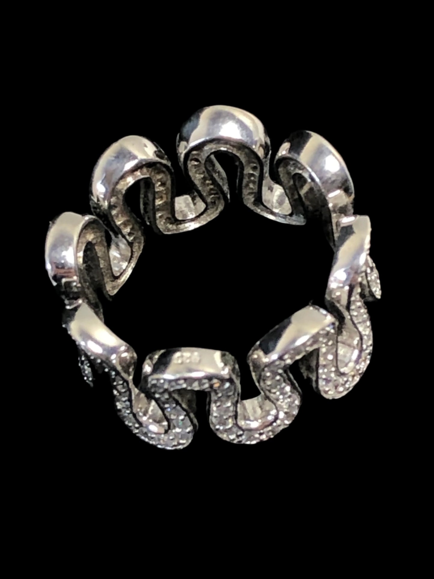 This ring oozes imaginative individuality. The band boasts a snaking line of clear glass stones diamonds against fine sterling silver.