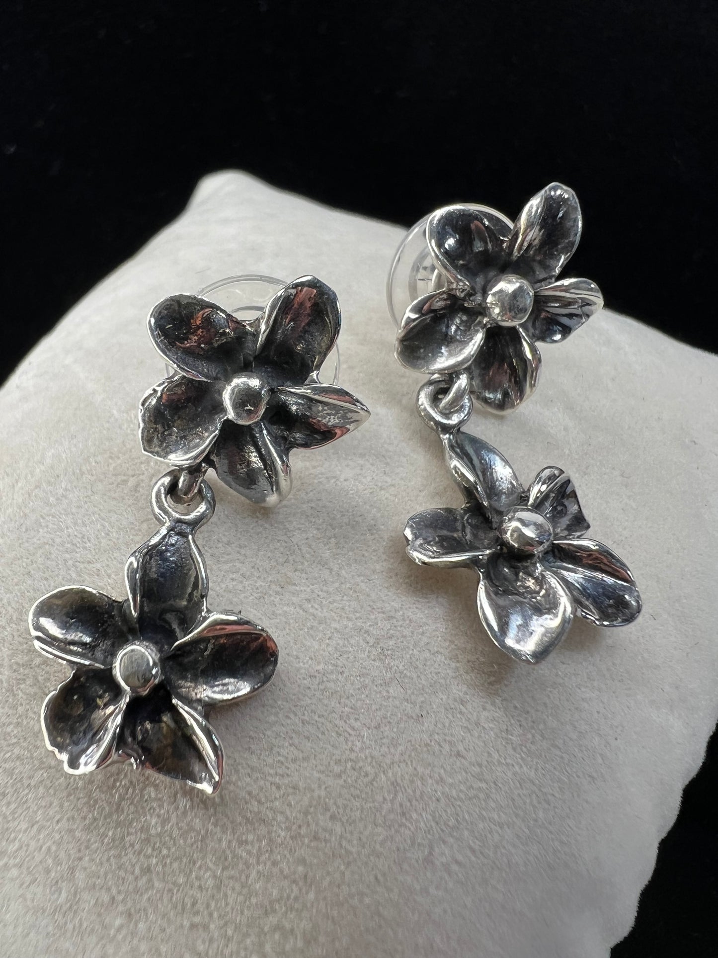 Add some floral charm to your outfit with these beautiful sterling silver earrings. One flower is attached to the post and another dangles, providing some gentle movement.